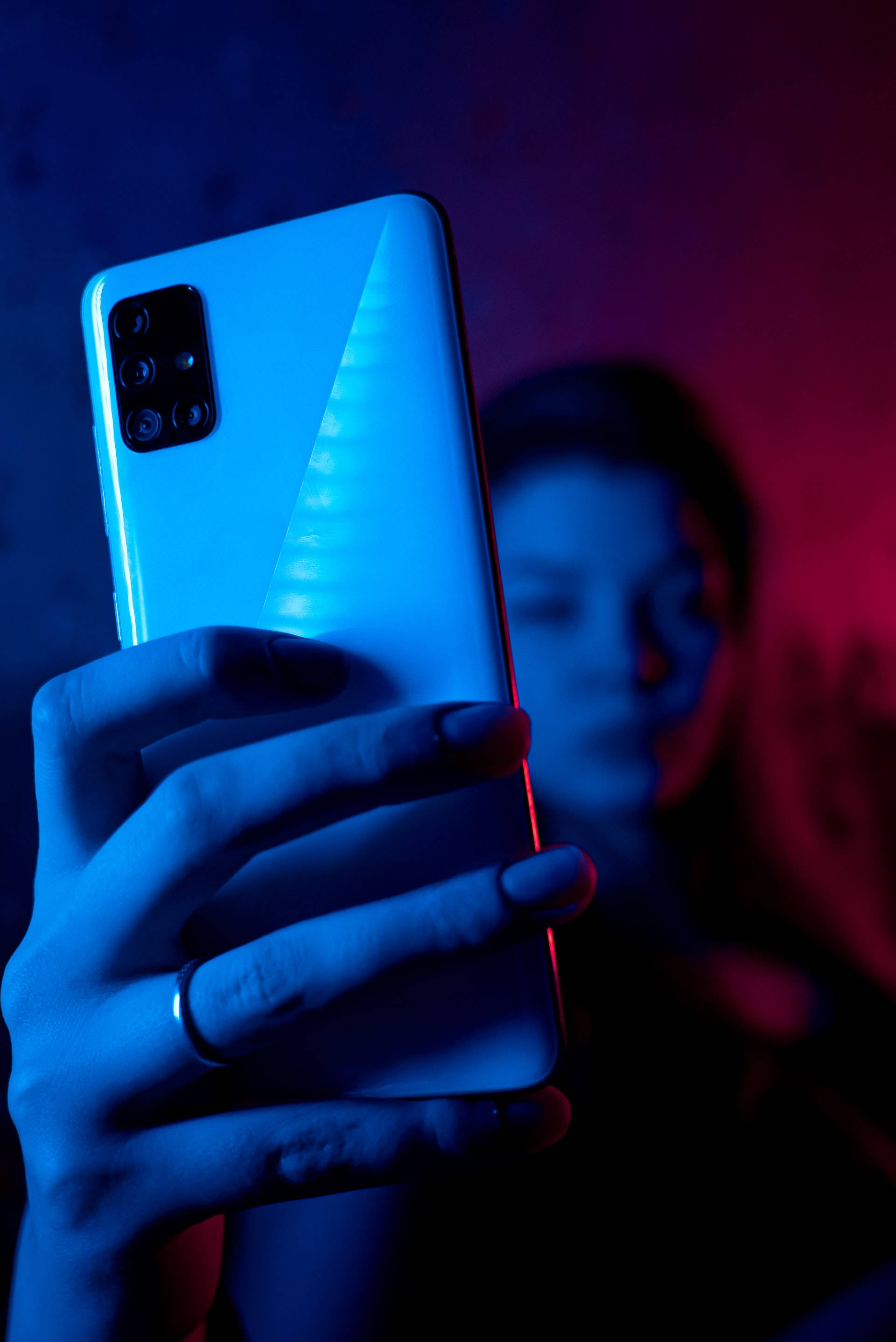 네온 블루 iPhone 속 전화기를 든 여성 배경화면