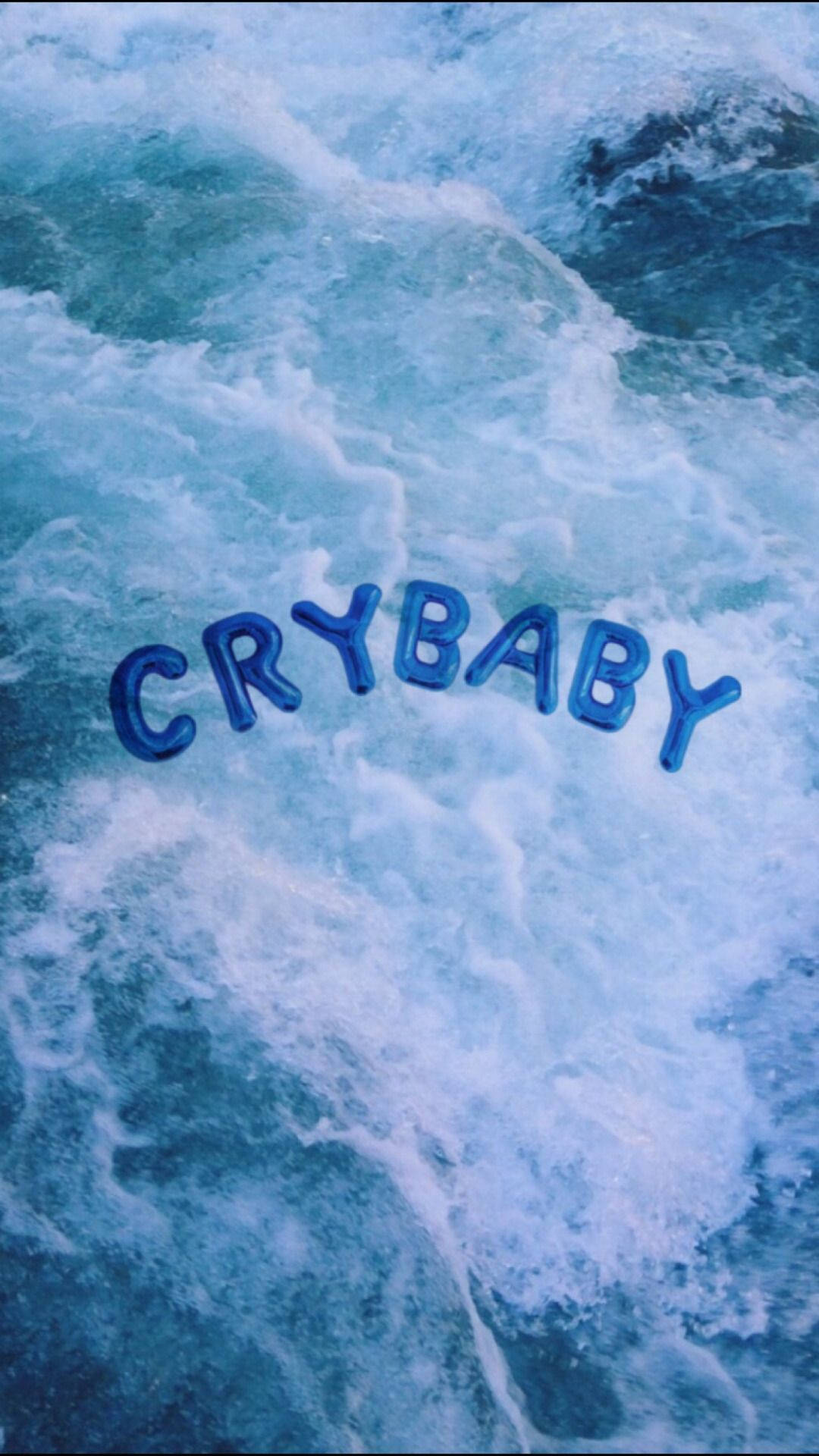 푸른 바다 위에 떠 있는 'Crybaby'라고 적힌 큰 풍선 글자가 있는 시원한 파란색 감성 배경화면