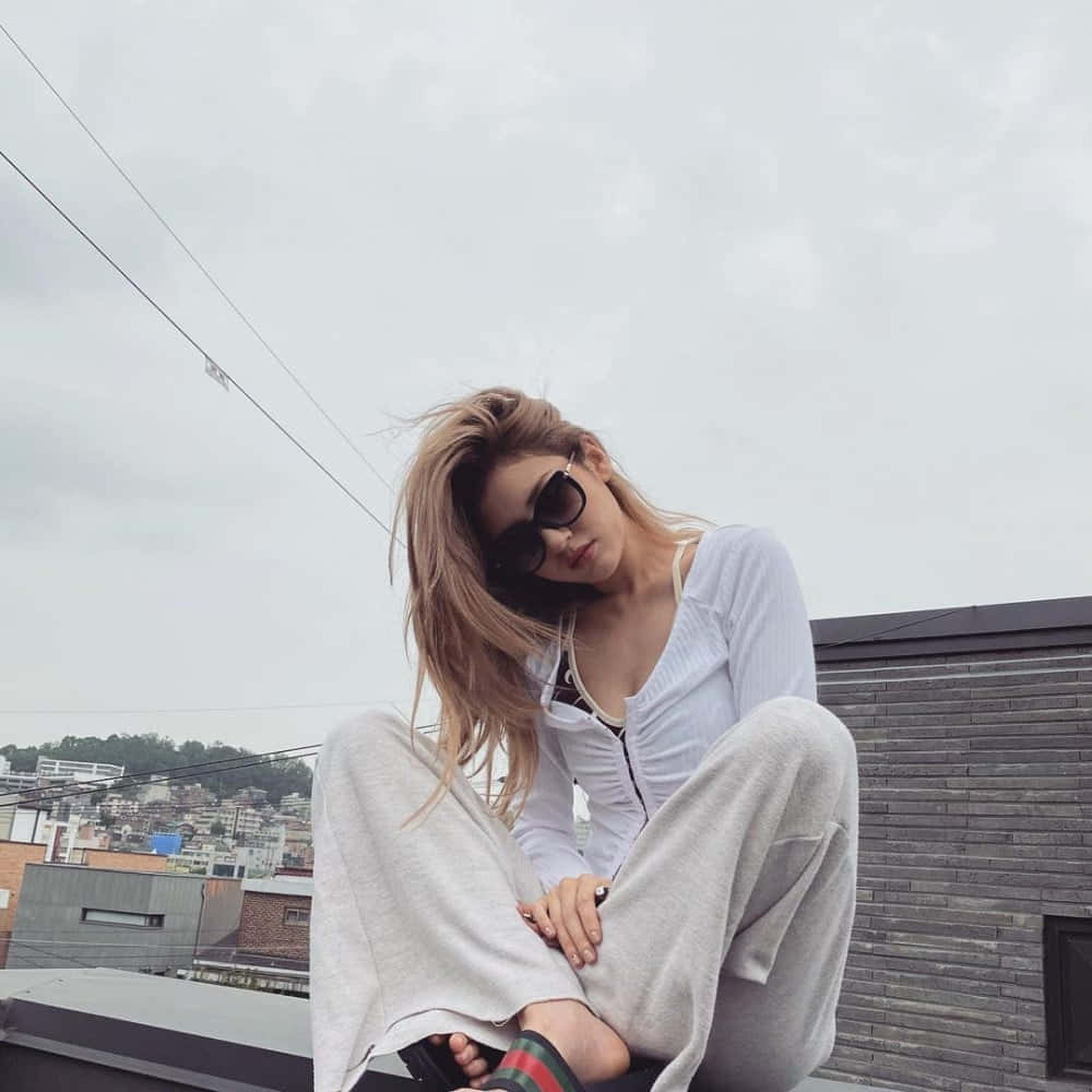 선글라스를 낀 채 지붕 위에 앉아 있는 여성 배경화면