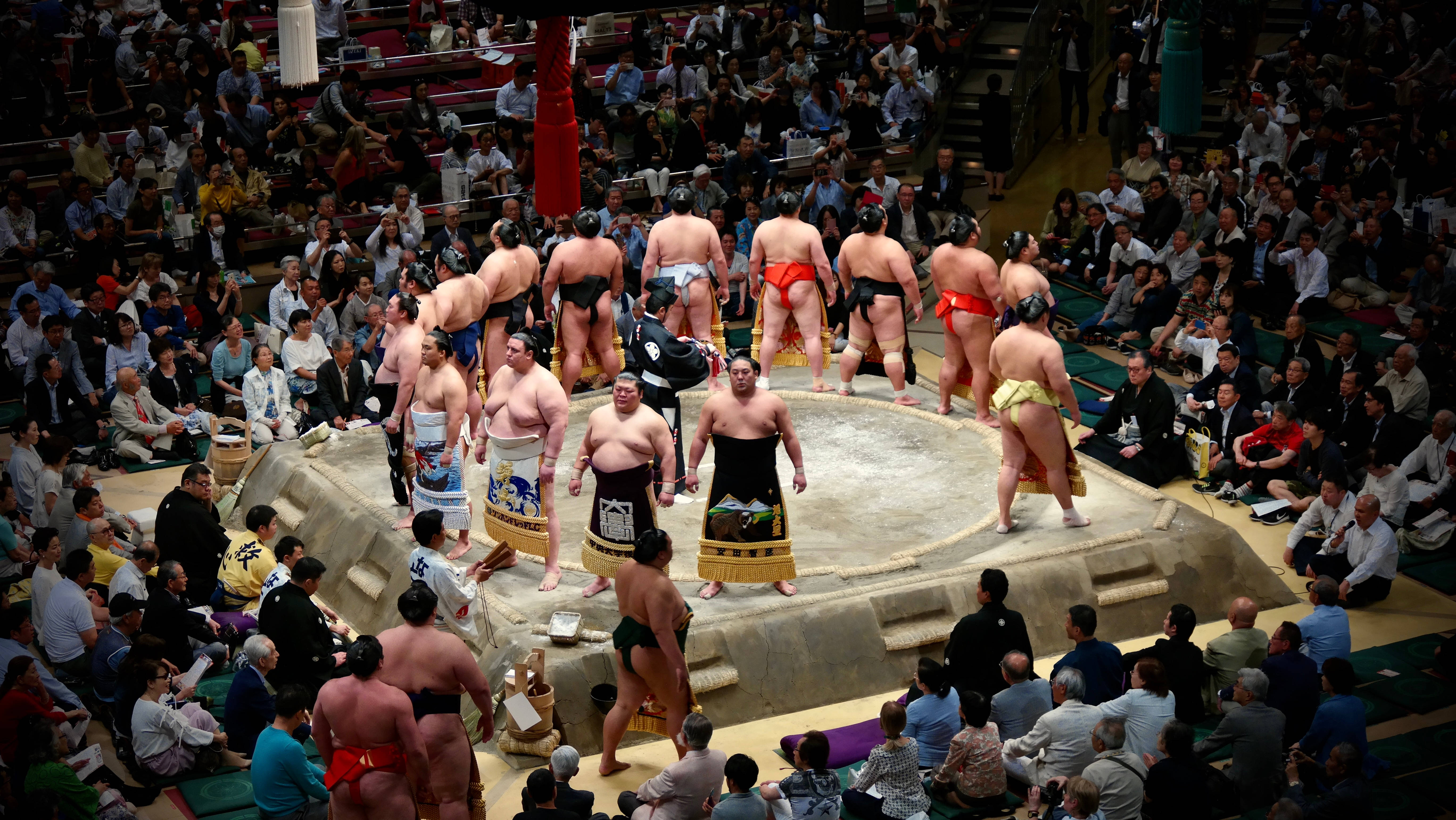 전통 일본 경기장에서 격돌하는 두 스모 선수 배경화면