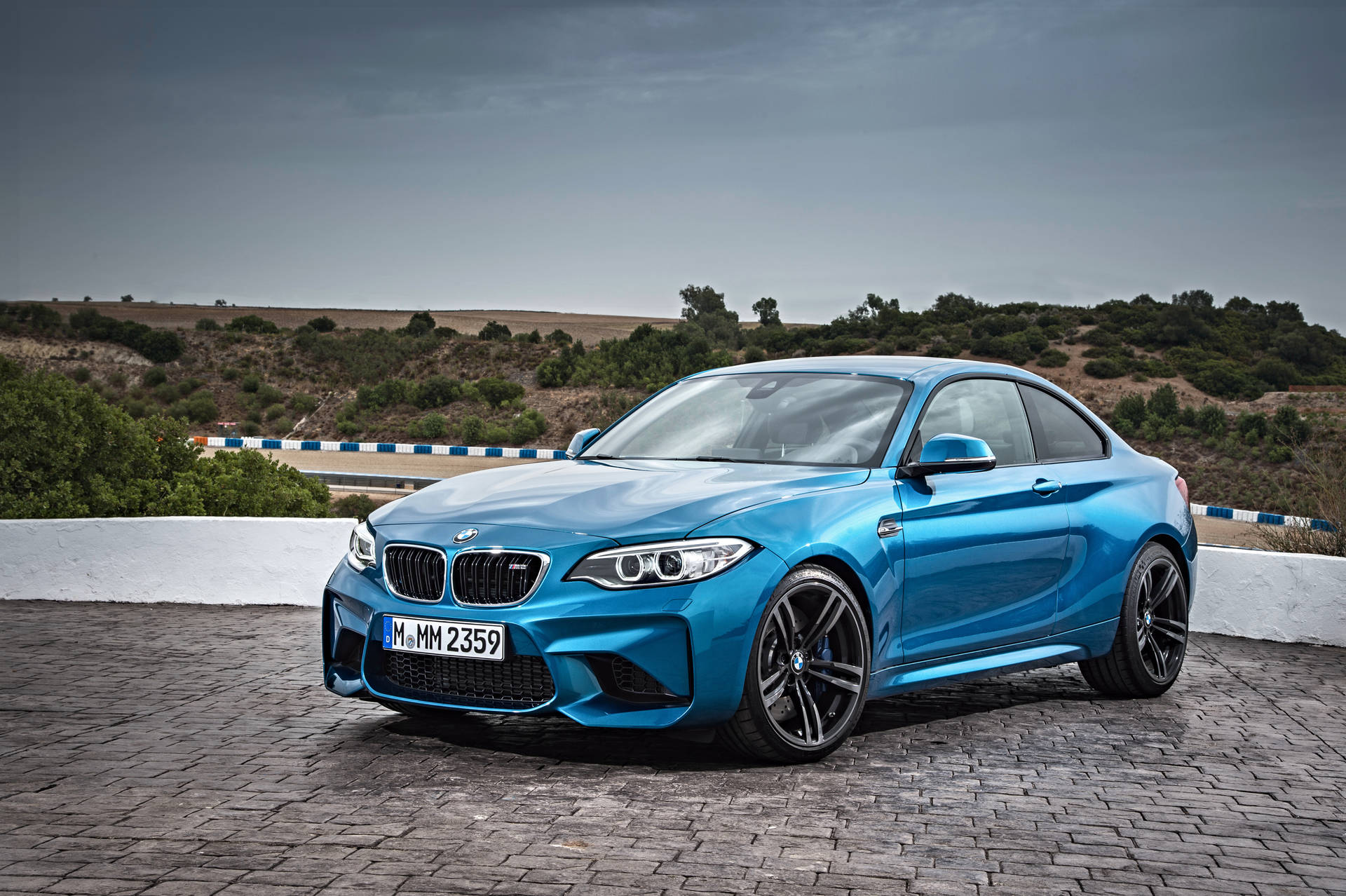 산 전망이 있는 포장 도로 위 파란색 BMW F87 배경화면