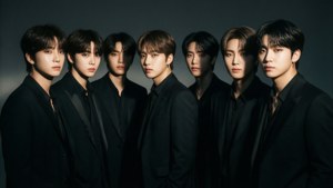세련된 검은 정장을 입고 드라마틱한 느와르 조명 아래 있는 BTS.