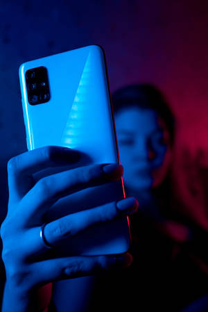 네온 블루 iPhone 속 전화기를 든 여성 — 샤오미 패드 9 프로 맥스 배경화면