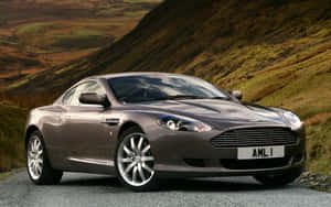 열린 도로 위의 세련된 Aston Martin DB9 — 스팀 덱 OLED 배경화면