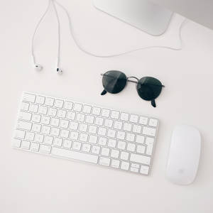 iMAC, 무선 키보드, 매직 마우스, 이어폰으로 구성된 흰색 Apple MAC 세트업의 미니멀리스트 배경화면 — 깔끔한 배경화면